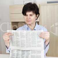 woman in middle age reading newspaper