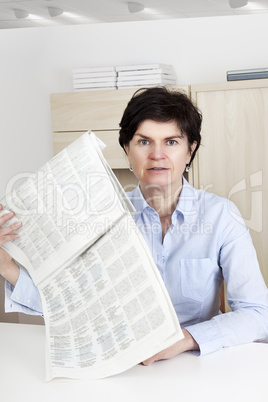 woman in middle age reading newspaper