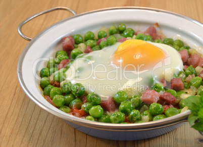 Peas cooked with ham and egg on a dish