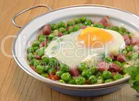 Peas cooked with ham and egg on a dish