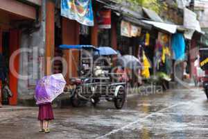 little girl in the rain on a philippines street