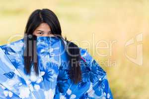 playful young girl peeking over her umbrella