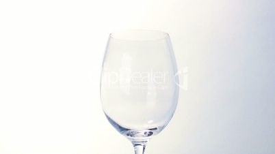 red wine poured into glass on white background