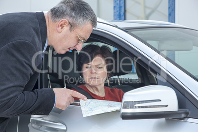 woman with car and map asks for the way