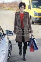 woman with shopping bags next car