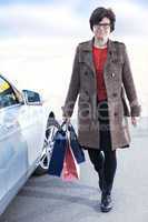 woman with shopping bags next car