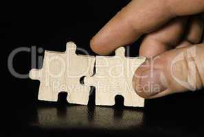 Wooden puzzle on black background. Close up