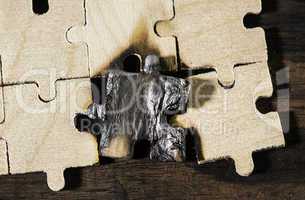 Burning wooden puzzle on dark background.
