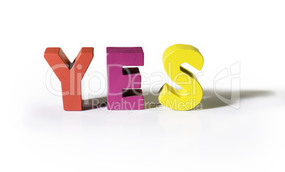 Multicolored word yes made of wood.