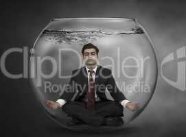 business man meditates under water in a fish bowl