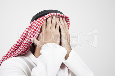 arab man covering his face
