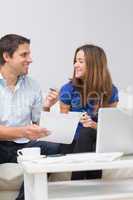 Smiling couple paying their bills online at home