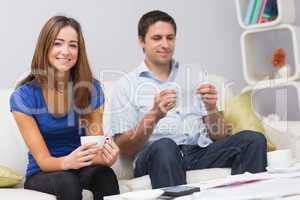 Portrait of a smiling couple with bills at home