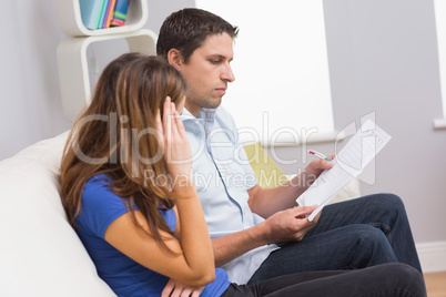 Stressed couple paying their bills at home