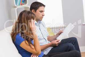 Stressed couple paying their bills at home