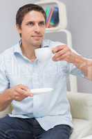 Thoughtful young man drinking tea at home