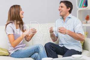 Cheerful couple enjoying their tea at home