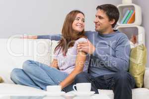 Loving couple looking at each other on sofa at home