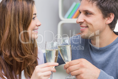 Close-up of a smiling young couple toasting flutes