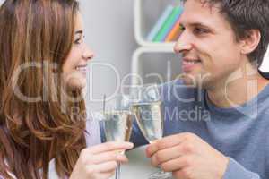 Close-up of a smiling young couple toasting flutes