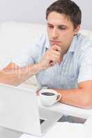 Close-up of a serious man using laptop at home