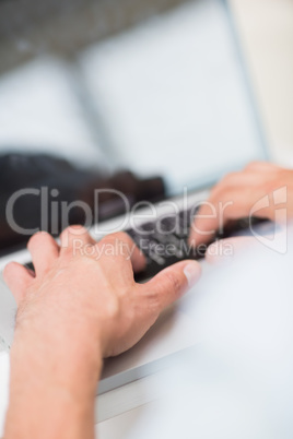 Hands using blurred laptop keyboard