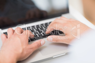 Hands using laptop keyboard