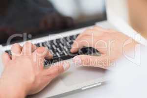 Hands using laptop keyboard