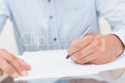 Mid section of a young man writing documents