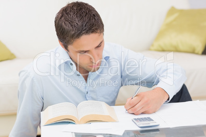 Man with bills and calculator in living room