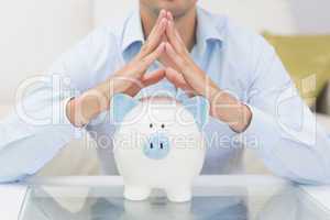 Mid section casual man with piggy bank in living room