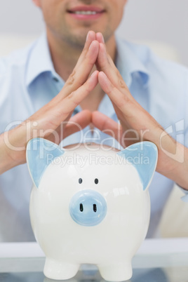 Close-up mid section man with piggy bank at home