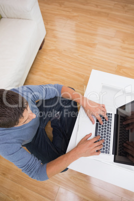 Overhead view of a man using laptop in living room