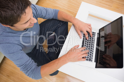 Overhead view of a man using laptop in living room