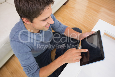 Overhead view of man using digital tablet in living room