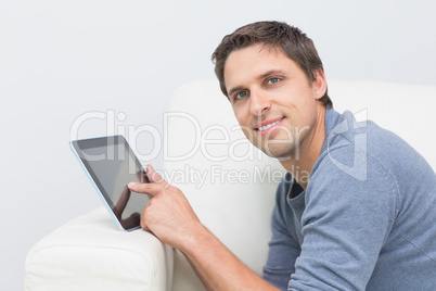 Portrait of a smiling man using digital tablet in living room