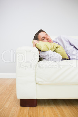 Tired businessman sleeping on sofa in living room