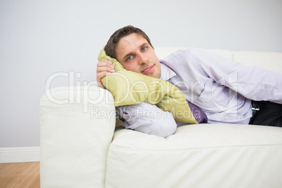 Portrait of a businessman lying on sofa in living room