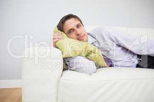 Portrait of a businessman lying on sofa in living room