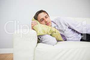 Tired businessman sleeping on sofa in living room