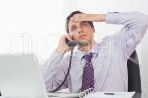 Worried businessman on call at desk