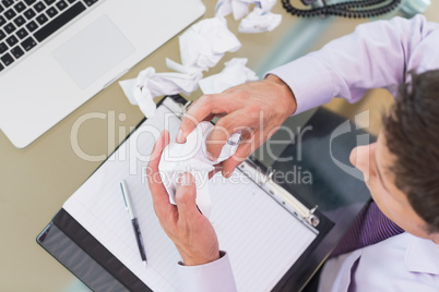 Businessman with laptop, diary and crumpled papers at office des