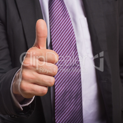Businessman in suit gesturing thumbs up