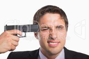 Close-up of a businessman holding a gun to head