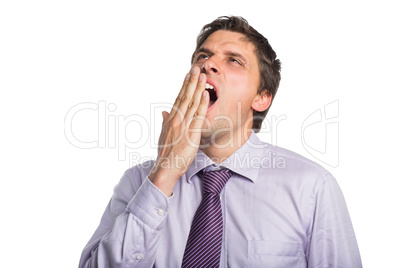 Young businessman in shirt and tie yawning