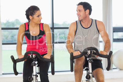 Man and woman working out at spinning class