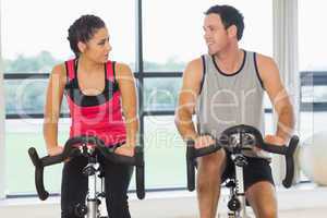 Man and woman working out at spinning class