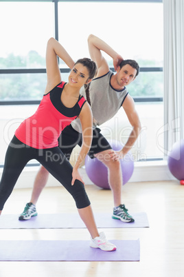 Two people doing power fitness exercise at yoga class