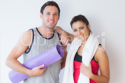 Portrait of a fit young couple with towel and exercise mat Portrait of a fit young couple with towel and exercise mat
