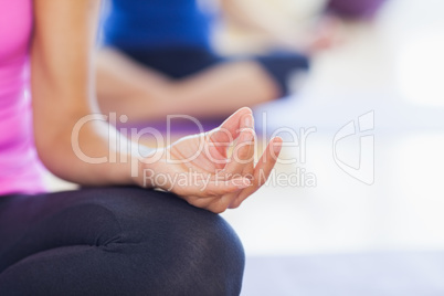 Close-up of cropped sporty women in lotus pose